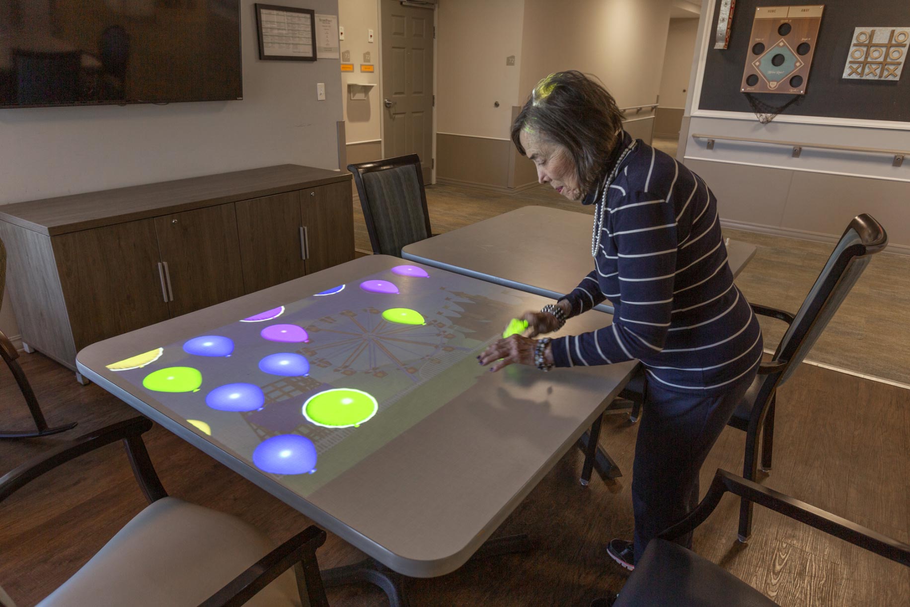 A resident participating in an interactive activity at a table