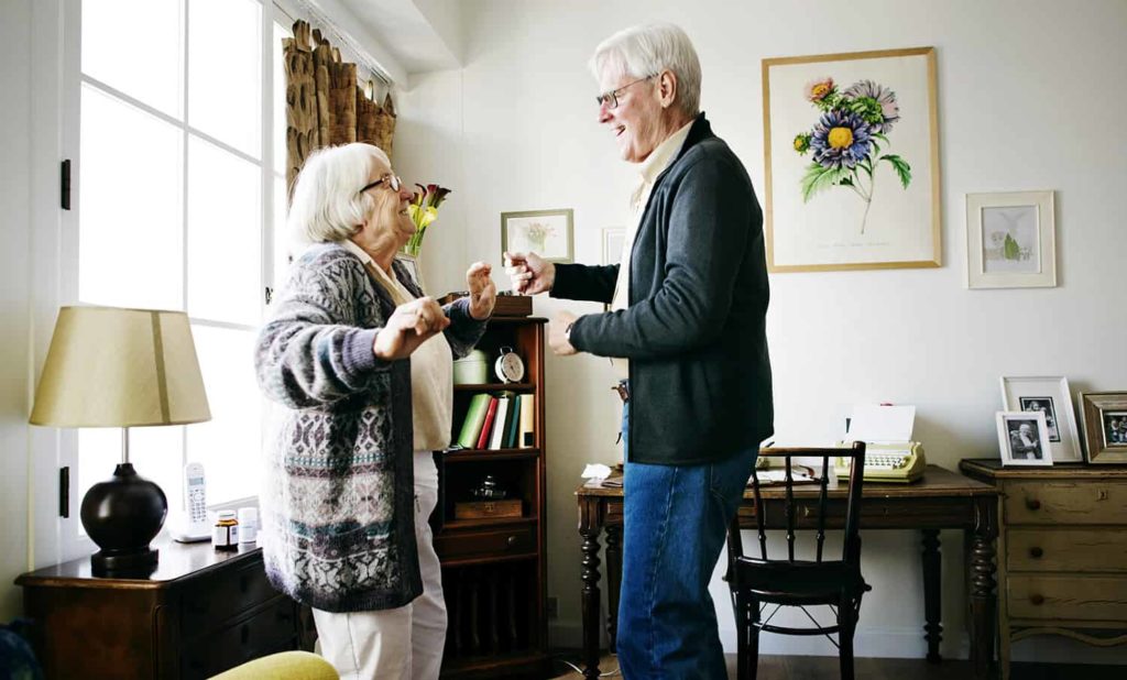 Residents engaging in a joyful dance in a cozy common area