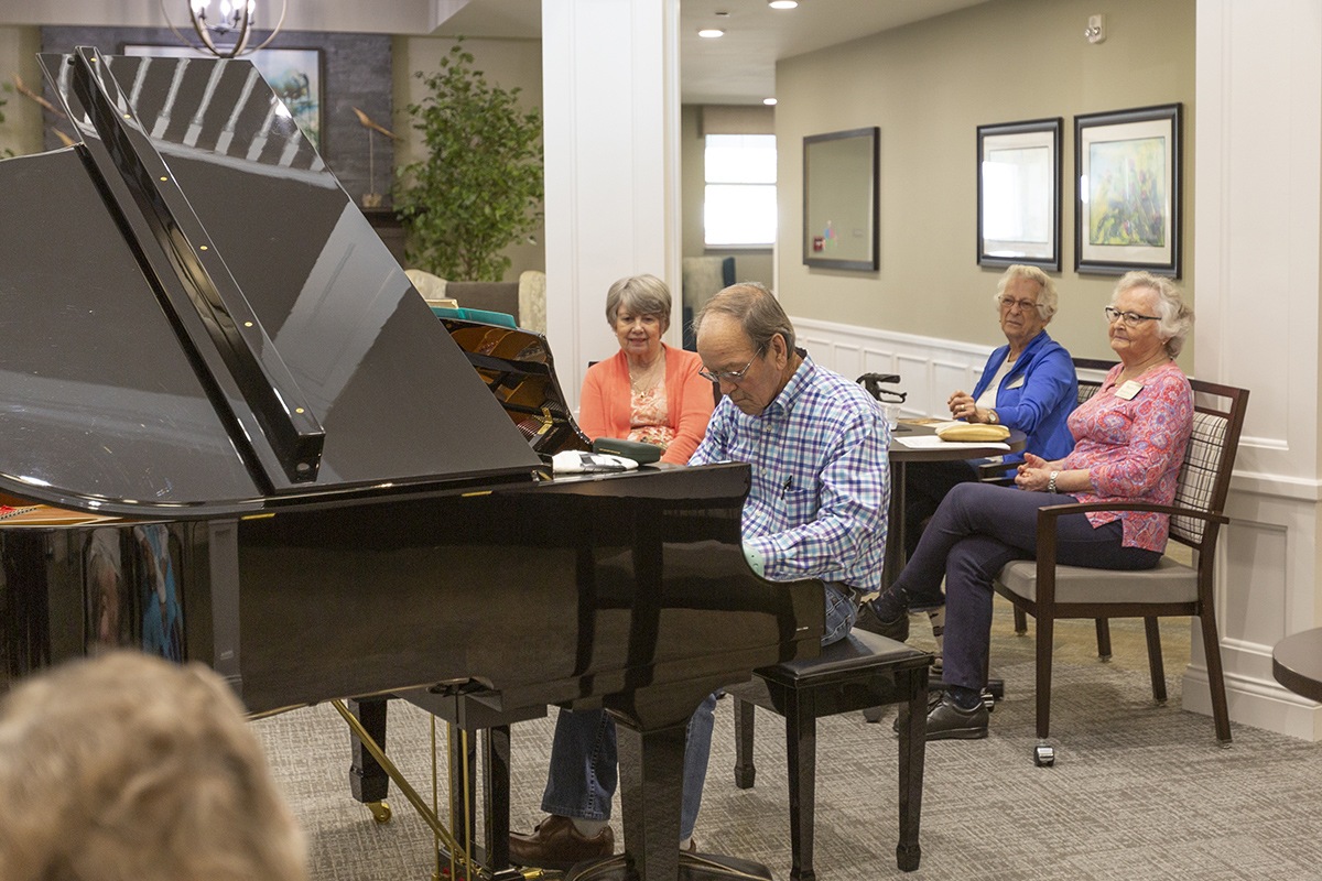 Residents enjoying live piano music in a common area