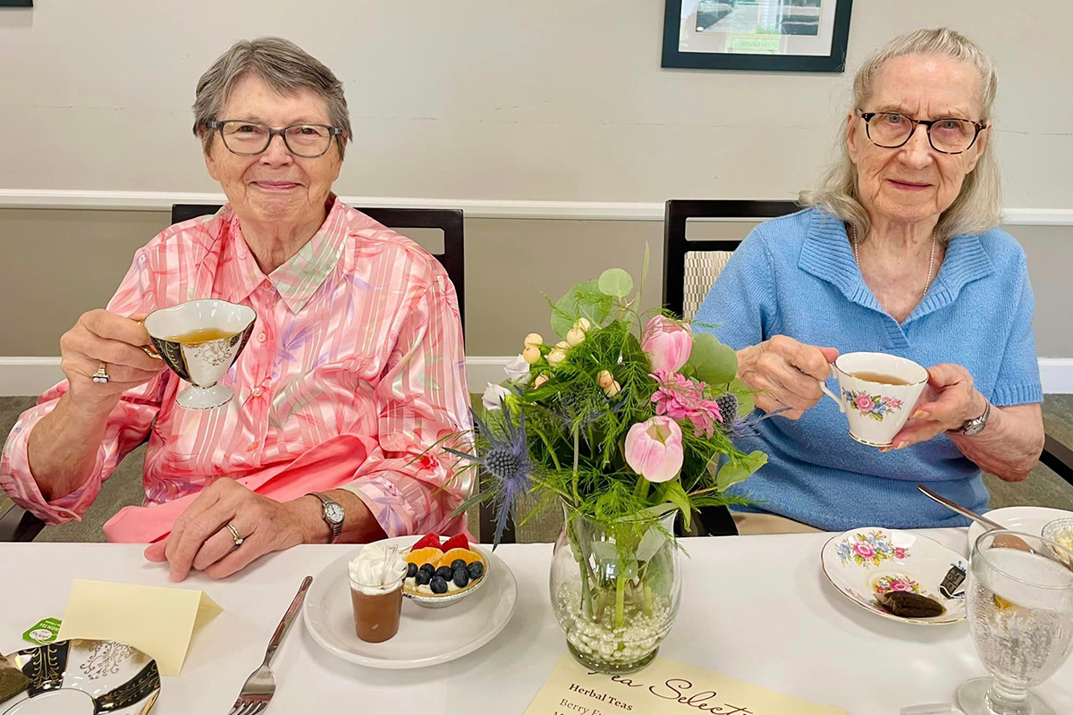 Two residents enjoying tea in a cozy dining space