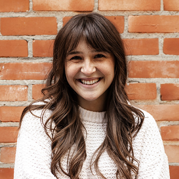 Smiling woman against a brick wall