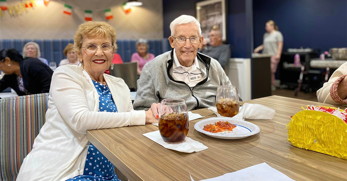 Residents enjoying a meal and conversation in a common area