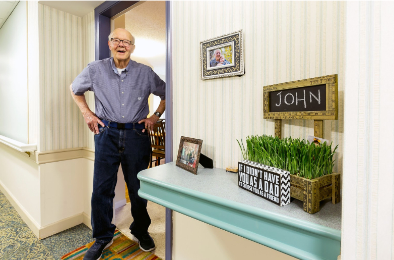 Resident standing in a hallway near personal decor