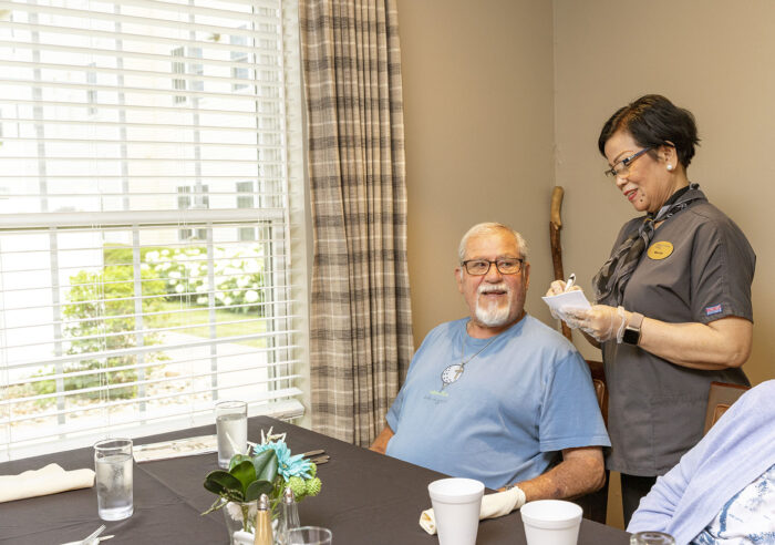 Resident and staff interacting in a cozy interior setting.