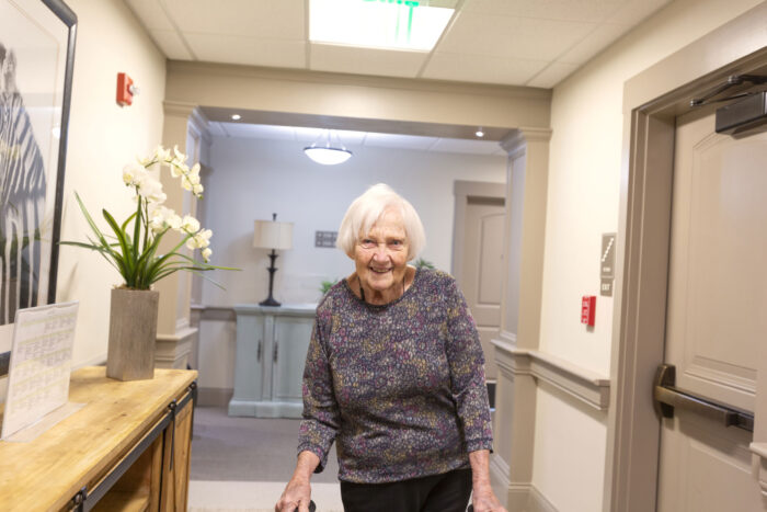 Resident walking through a facility hallway