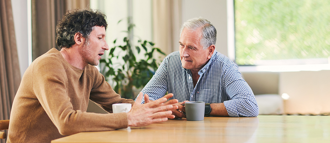 Two men engaged in conversation at a table