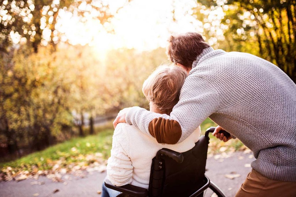 A caregiver and a resident enjoying a walk in an outdoor area