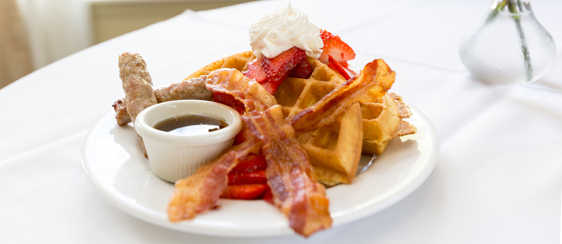 Plate of waffles with fruit and syrup