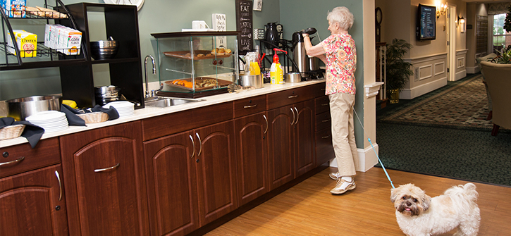 A resident enjoying drinks in the dining area with a dog