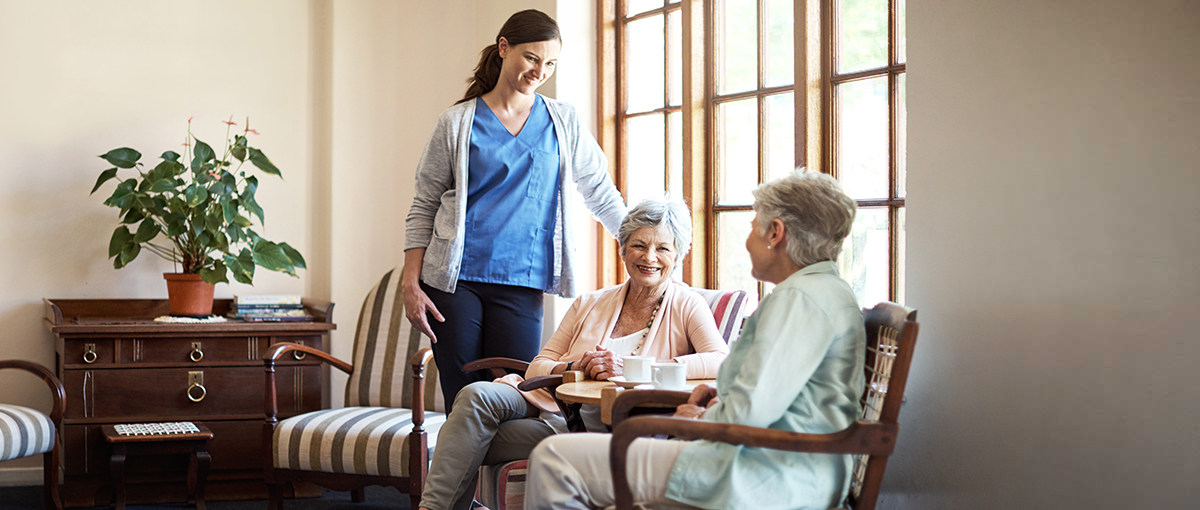 Care staff interacting with residents in a cozy lounge area
