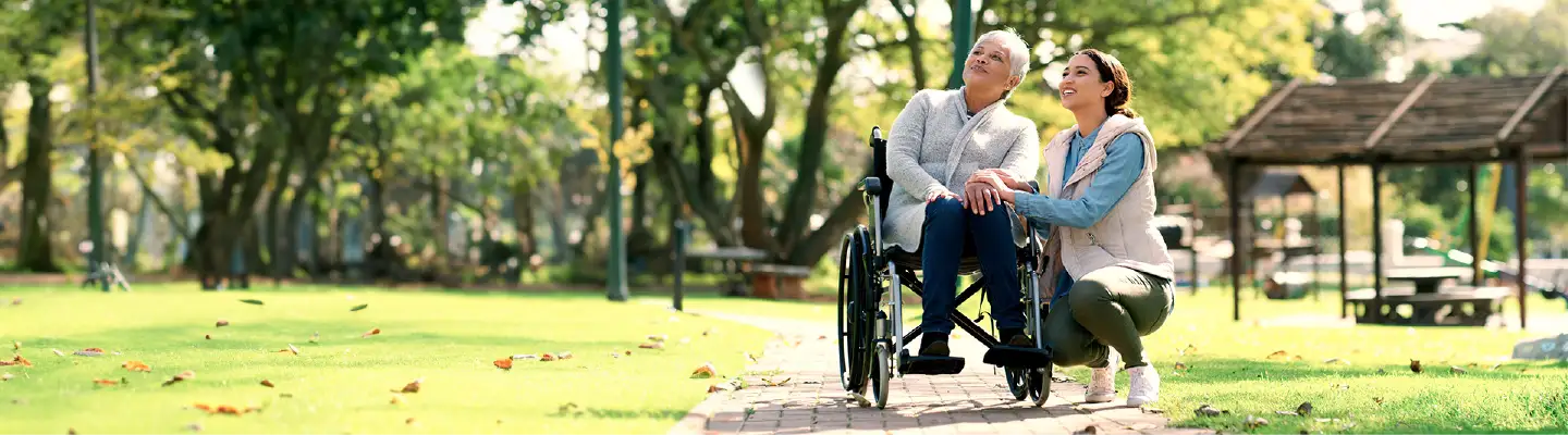 A resident and staff member enjoying outdoor time in a park