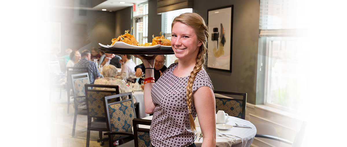 Staff member serving food in dining area