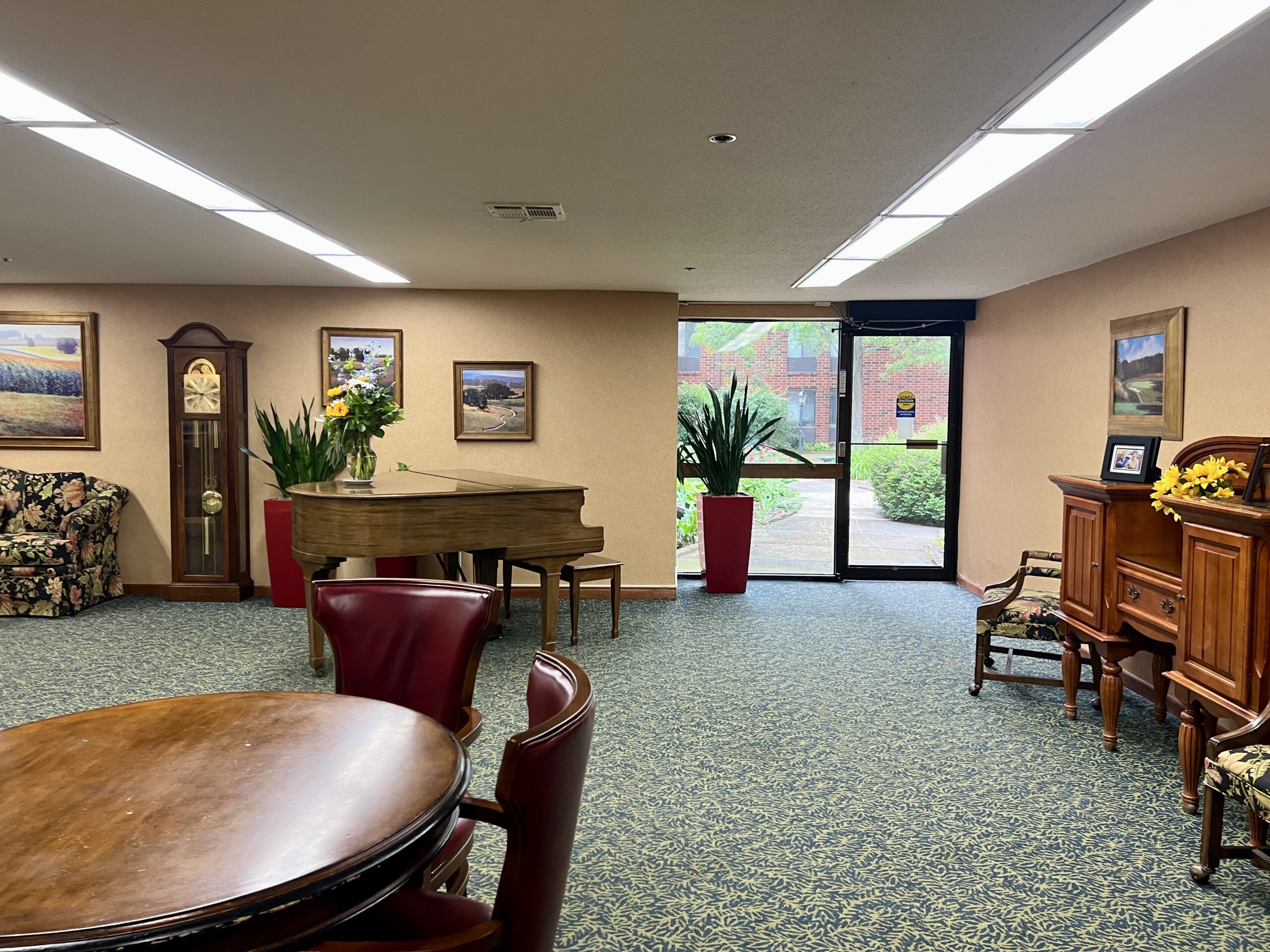 Common area with piano, seating, and plants