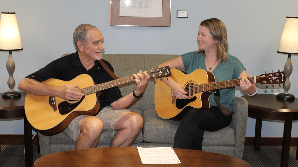 Residents playing guitar together in a common area