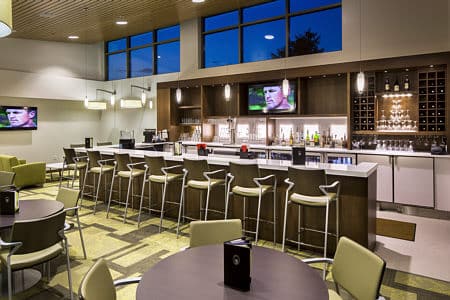 Modern lounge area with bar seating and televisions