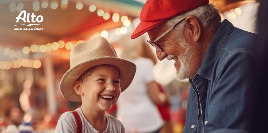 A senior man interacting happily with a young child