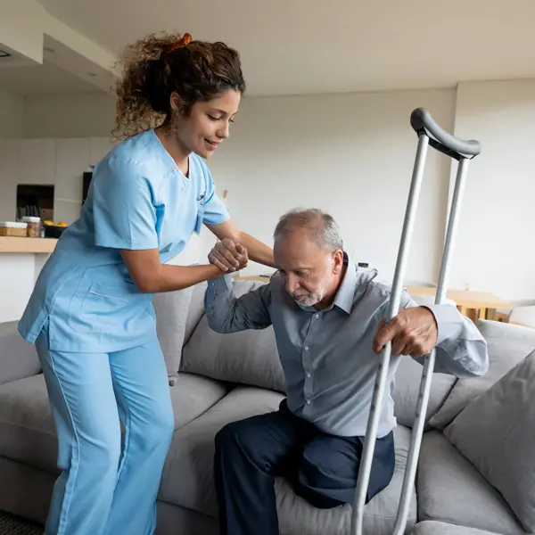 A caregiver assisting an elderly man in a modern living space