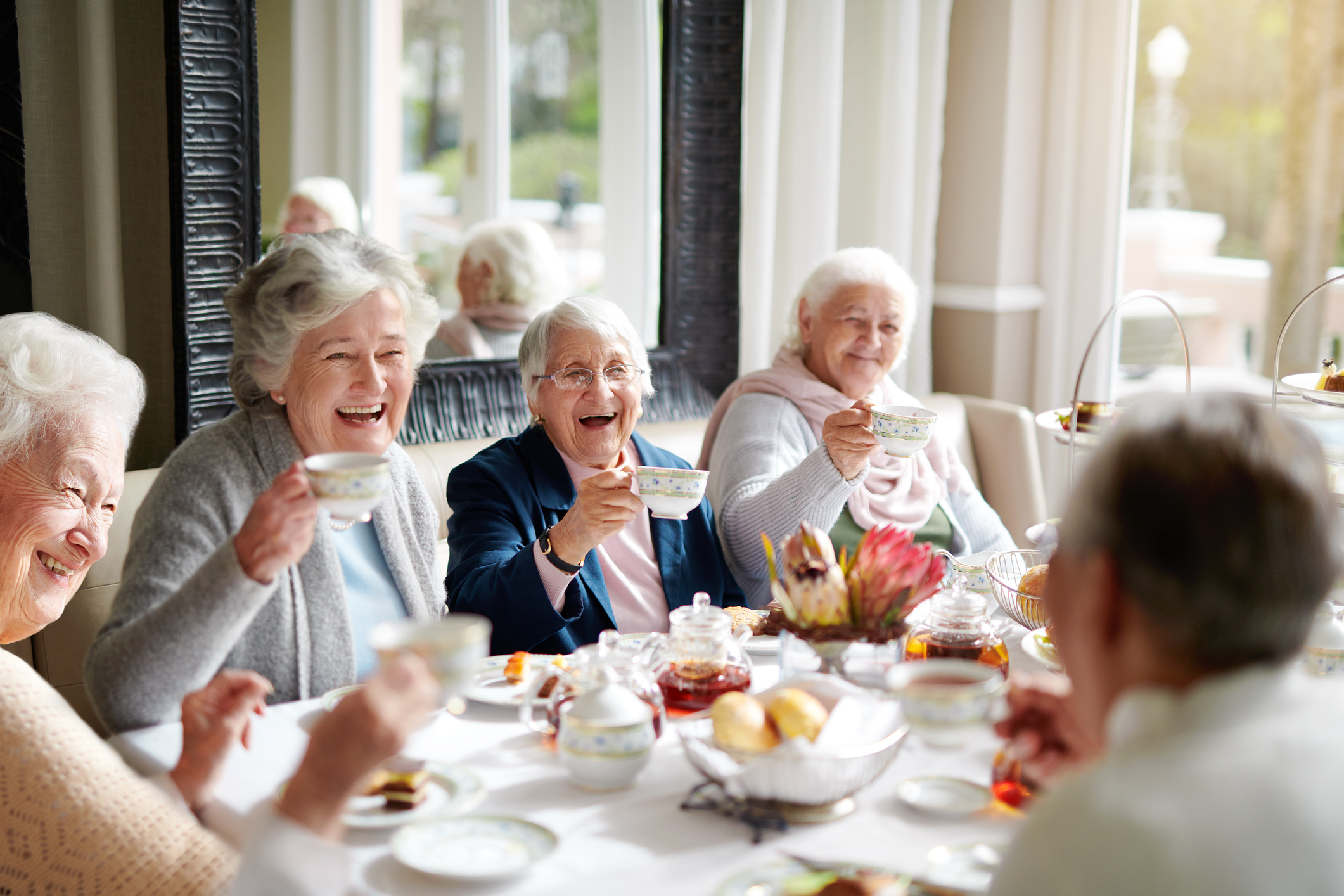 Residents enjoying tea and pastries in a dining area