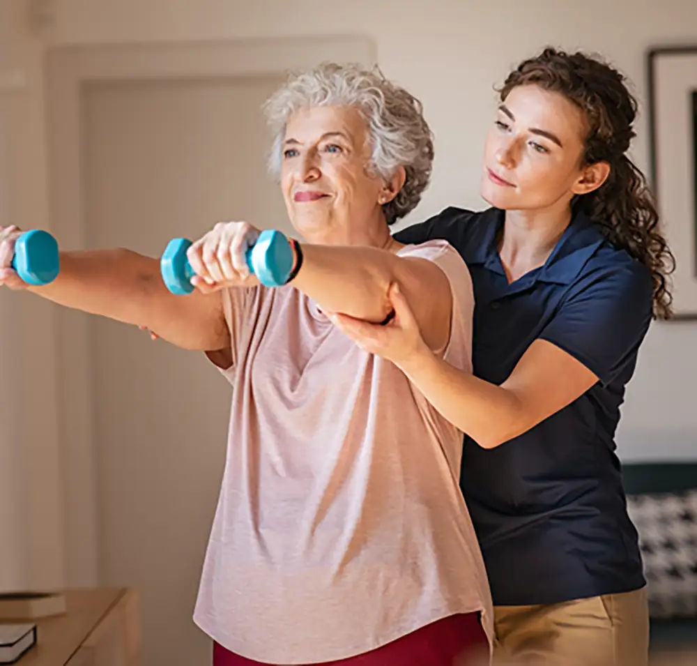 Staff assisting a resident with exercise using dumbbells