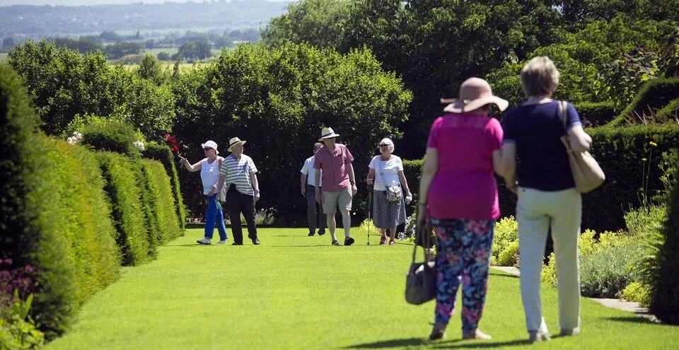 Residents enjoying a walk in a beautifully landscaped garden