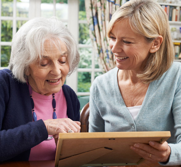 Resident and staff member looking at a photo frame together