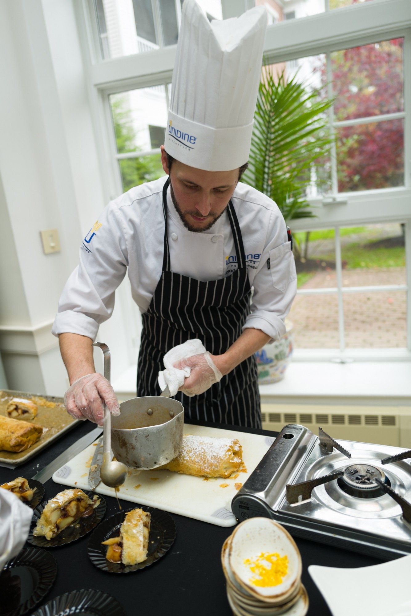 Chef preparing food in a bright dining area