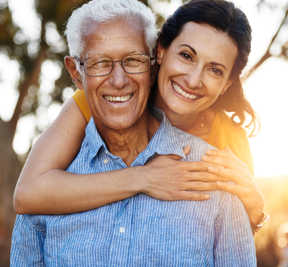 Smiling elderly man with caregiver in an outdoor setting