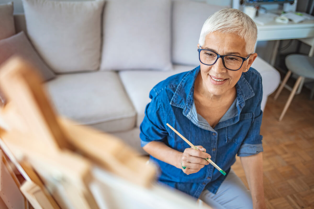 Senior resident painting in an inviting common area