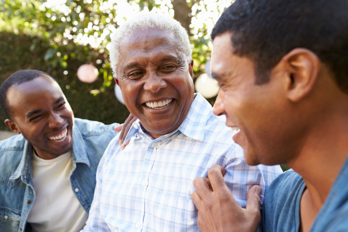 Three men enjoying time together outdoors in a garden