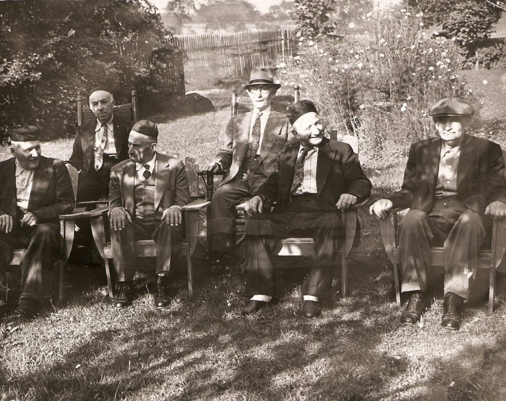 Group of men sitting in chairs outdoors