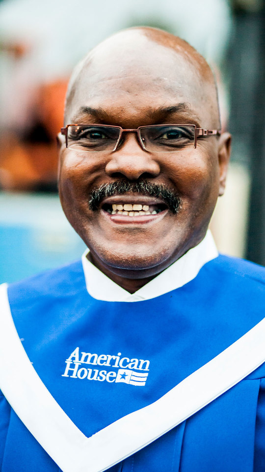 A smiling resident in a blue choir robe