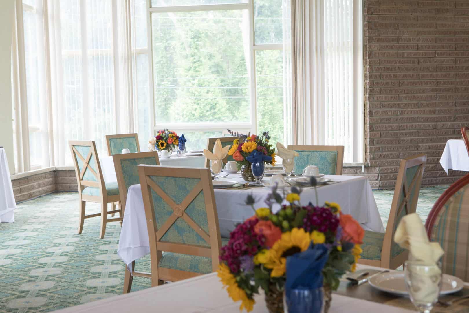 Bright dining room with floral centerpieces and table settings