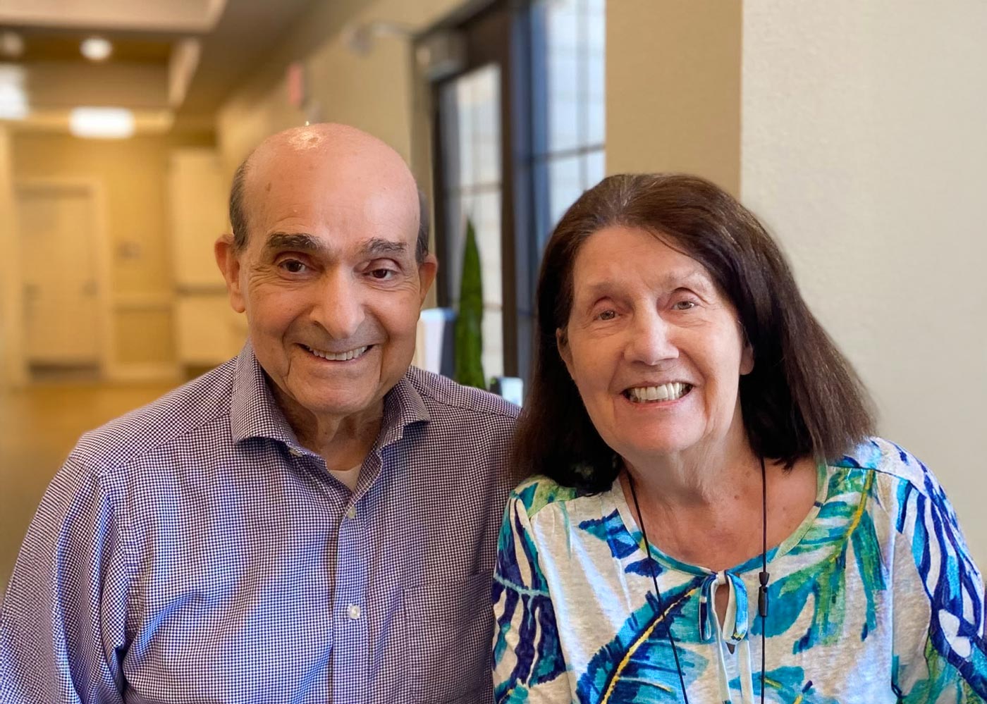 Two residents smiling in the facility's common area