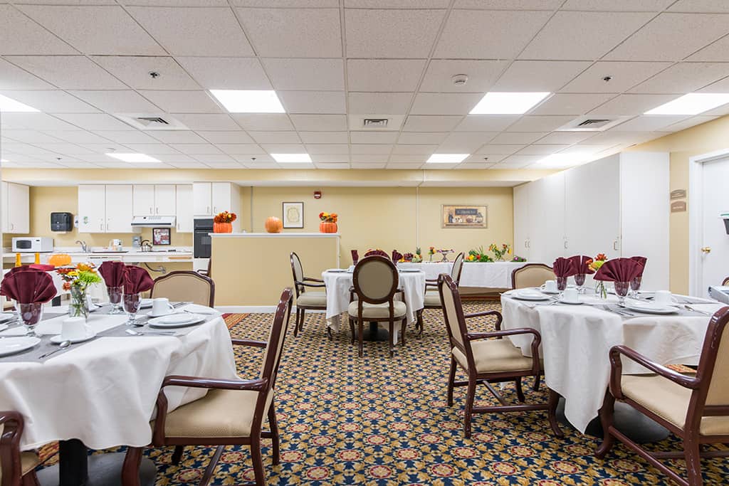 Dining room set up for a meal with tables and decorations