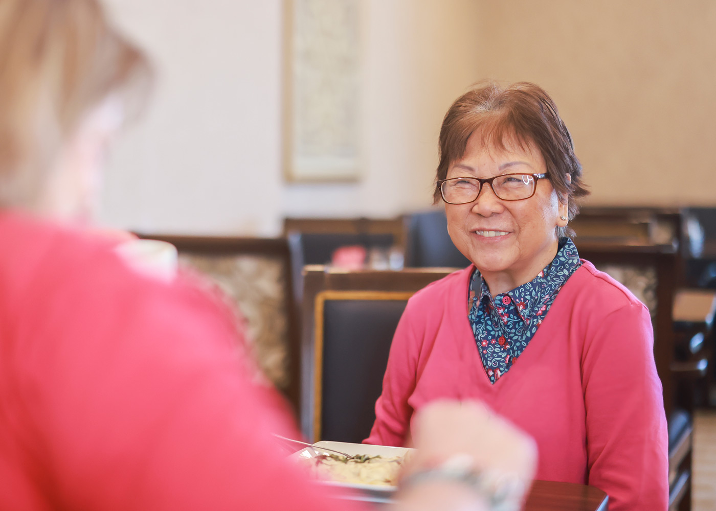 A smiling resident enjoying a meal in a dining area