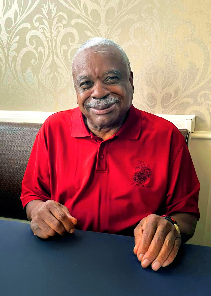Smiling resident in a red polo shirt at a table