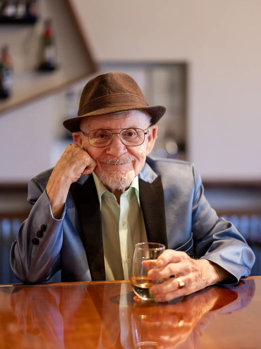 An elderly man enjoying a drink at a bar