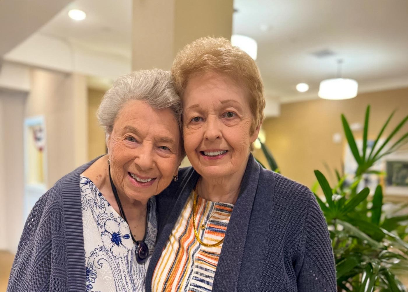 Two smiling residents in a common area of the facility