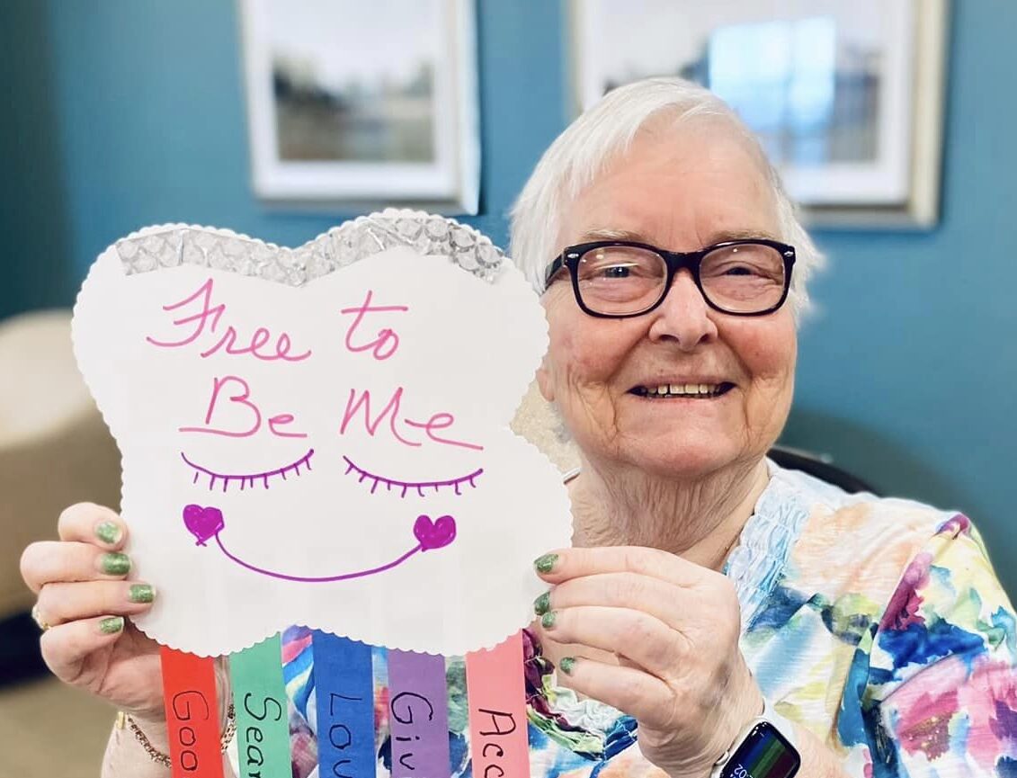 Resident holding a colorful sign in a common area