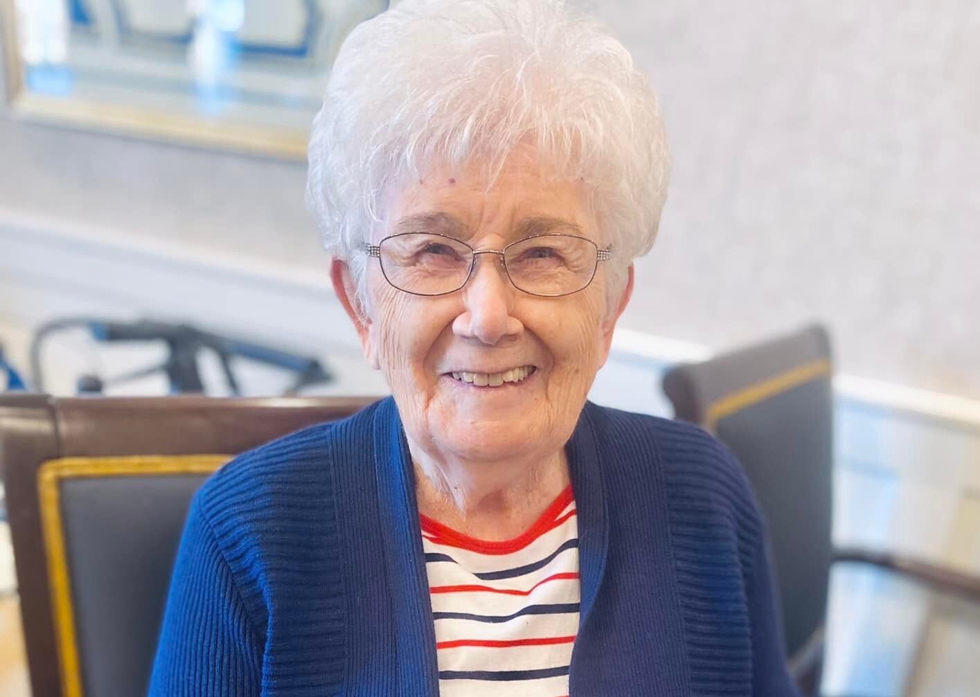 A smiling resident in a cozy facility setting