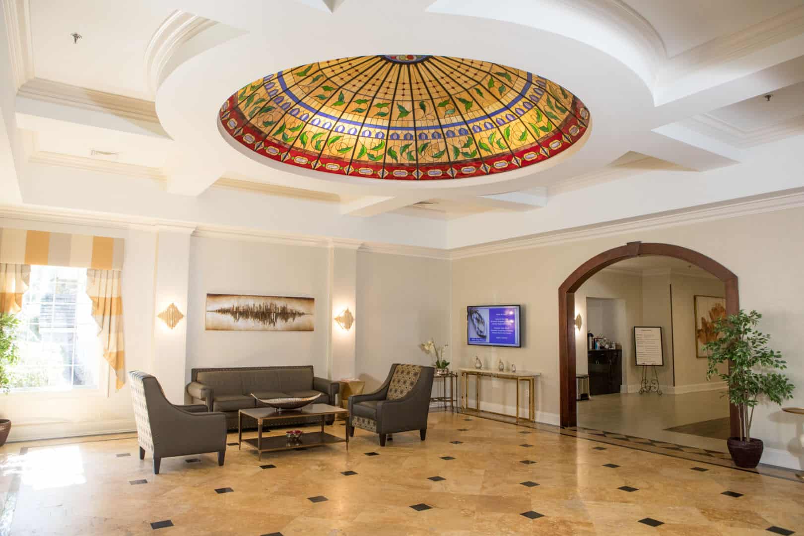 Bright lobby area with decorative ceiling and seating