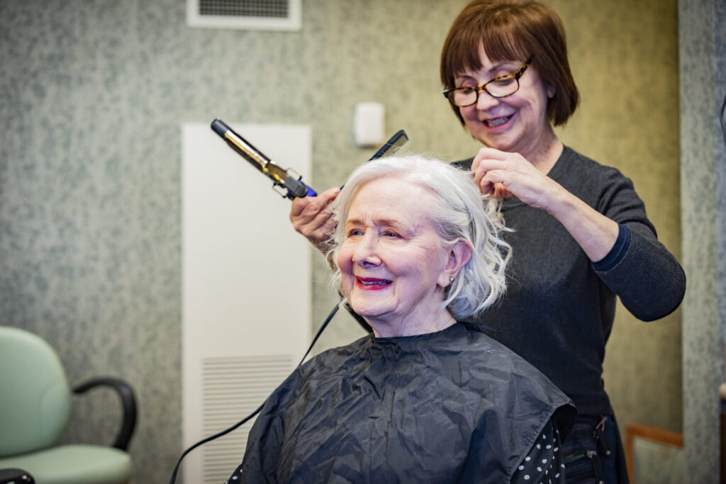 Resident receiving a hair styling service