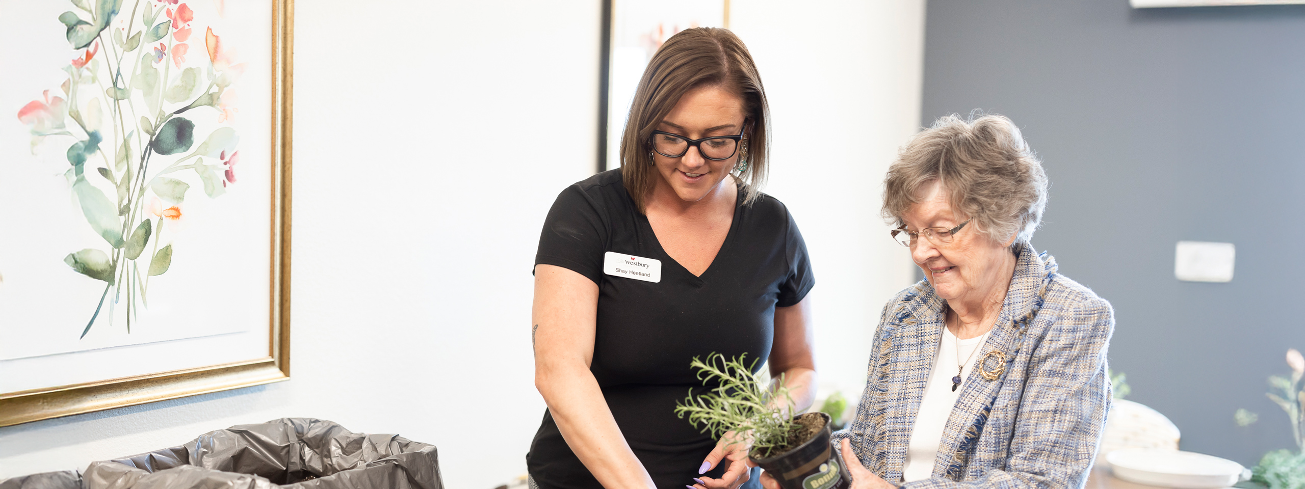 Staff member assisting resident with plant.