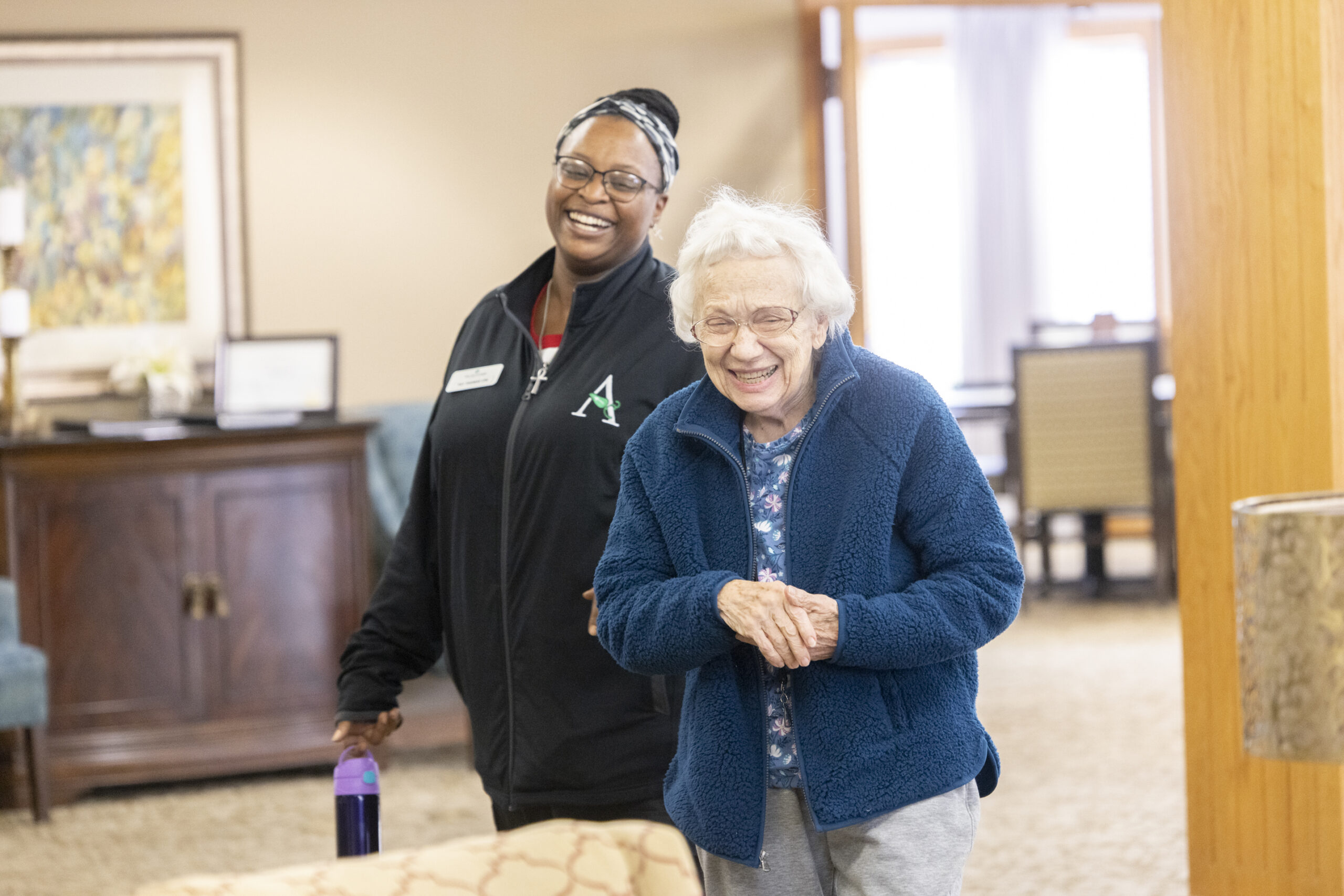 Staff member and resident smiling in a common area