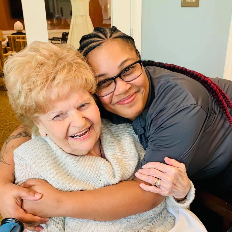 A resident and staff member sharing a joyful moment