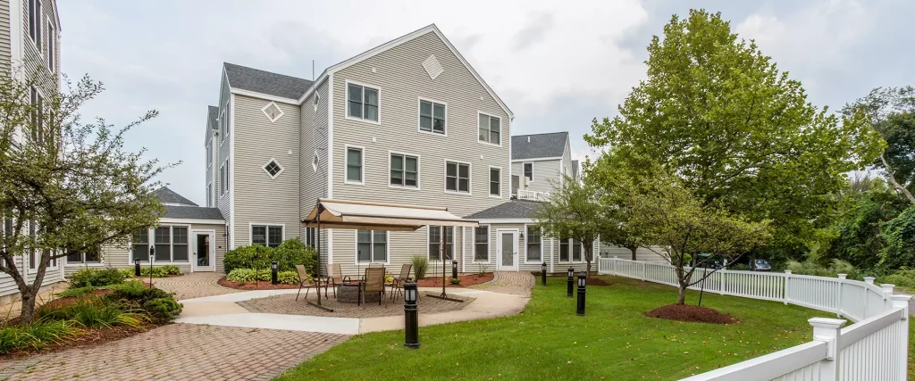 Exterior view of a senior living facility with outdoor seating