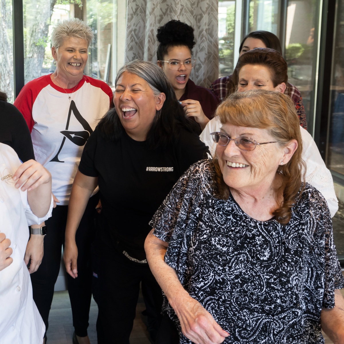 Staff and residents sharing a joyful moment indoors