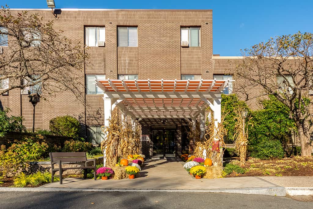 Exterior view of the facility entrance adorned with autumn decorations
