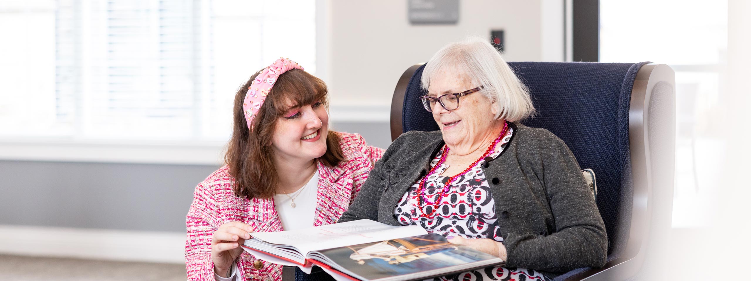 Caregiver and resident looking at a book together