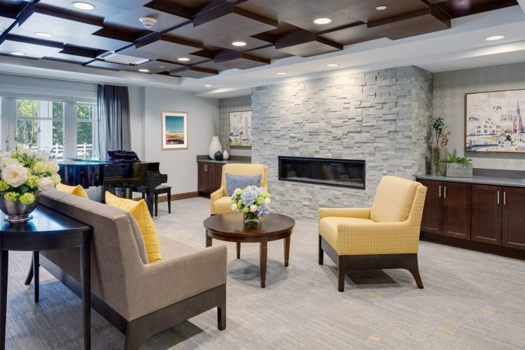 Common area with seating and fireplace in a senior living facility